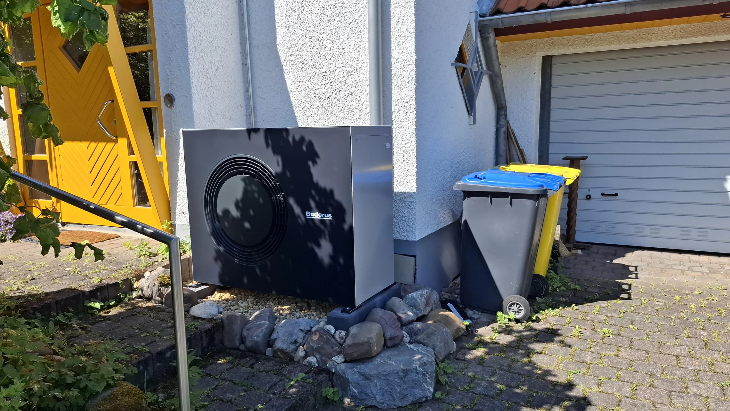 Wärmepumpen-Außeneinheit neben der Garageneinfahrt